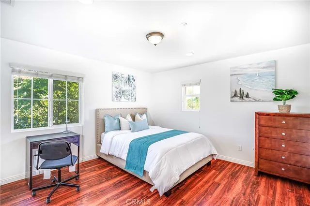 a bedroom with a bed and a dresser next to a window