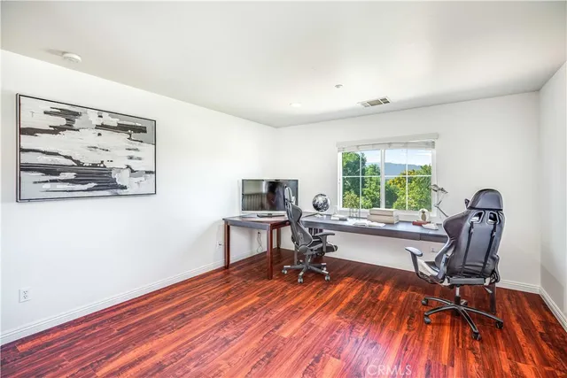 a view of a workspace with furniture and a window