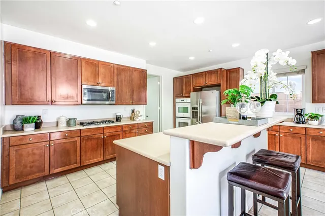 a kitchen with stainless steel appliances kitchen island granite countertop a sink and cabinets