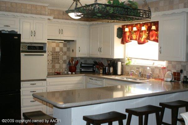 6018 Calumet Road Amarillo, TX 79106 - Photo 4 of 9 a kitchen with stainless steel appliances granite countertop a sink and a refrigerator