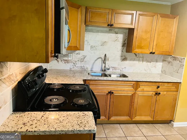 a view of a kitchen stove sink and cabinets