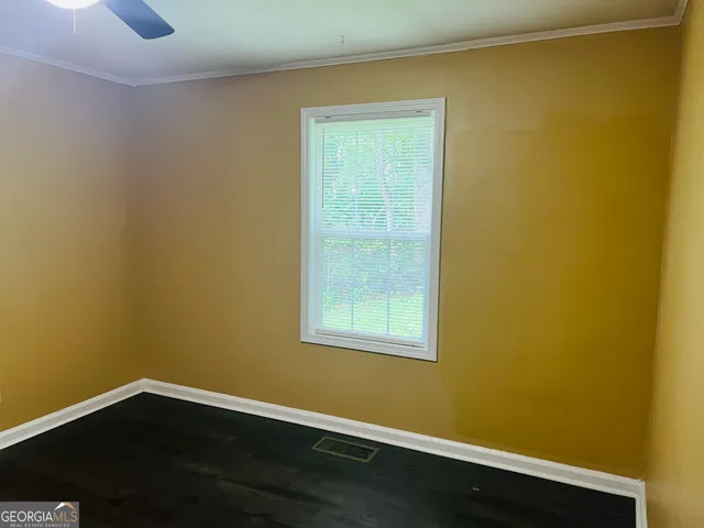 a view of a room with wooden floor and a window