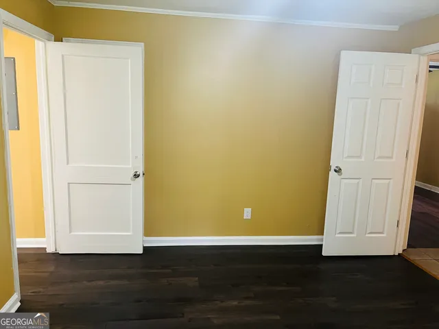 a view of a room with wooden floor and a window