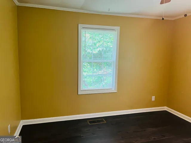 a view of a room with wooden floor and a window