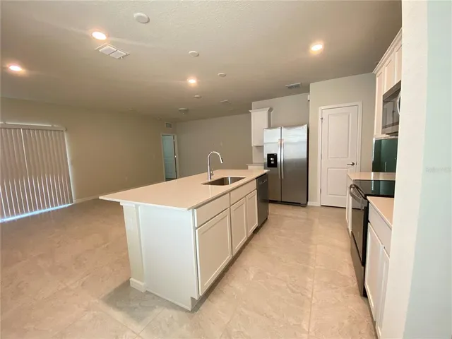 a kitchen with a refrigerator a sink and a stove top oven