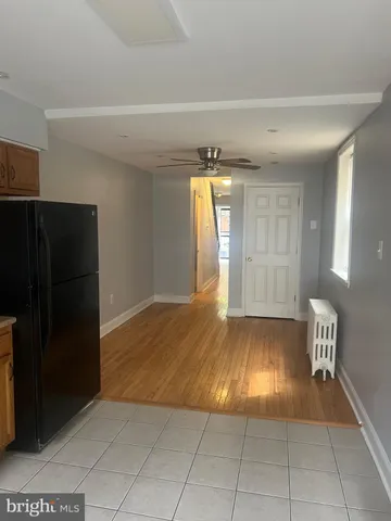 a view of empty room with kitchen and window