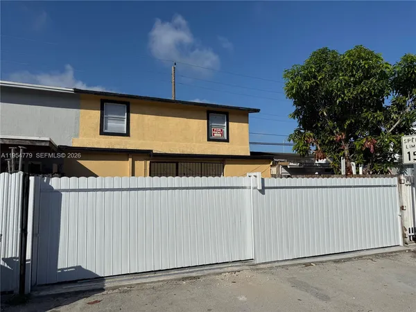 a view of a house with a wooden fence