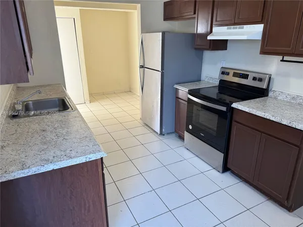 a kitchen with a stove cabinets and a refrigerator