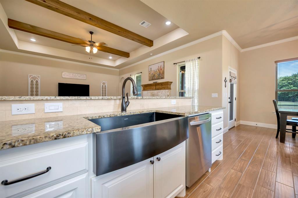 3224 North Cardinal Road Azle, TX 76020 - Photo 17 of 40 Kitchen featuring a stainless steel farmhouse sink, granite countertops, white cabinetry with dark hardware, and ceramic tile flooring