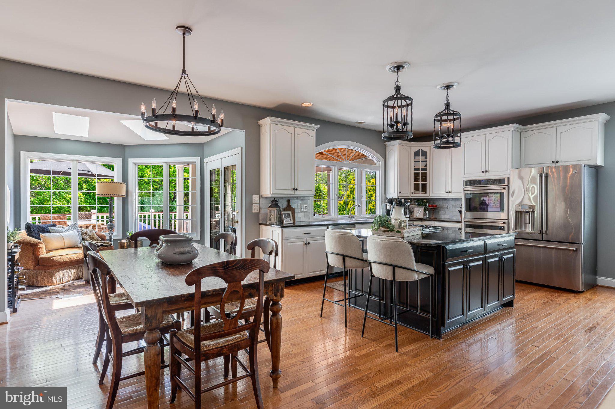 25554 Mimosa Tree Court Chantilly, VA 20152 - Photo 25 of 85 a kitchen with stainless steel appliances granite countertop a stove a refrigerator a kitchen island a dining table and chairs