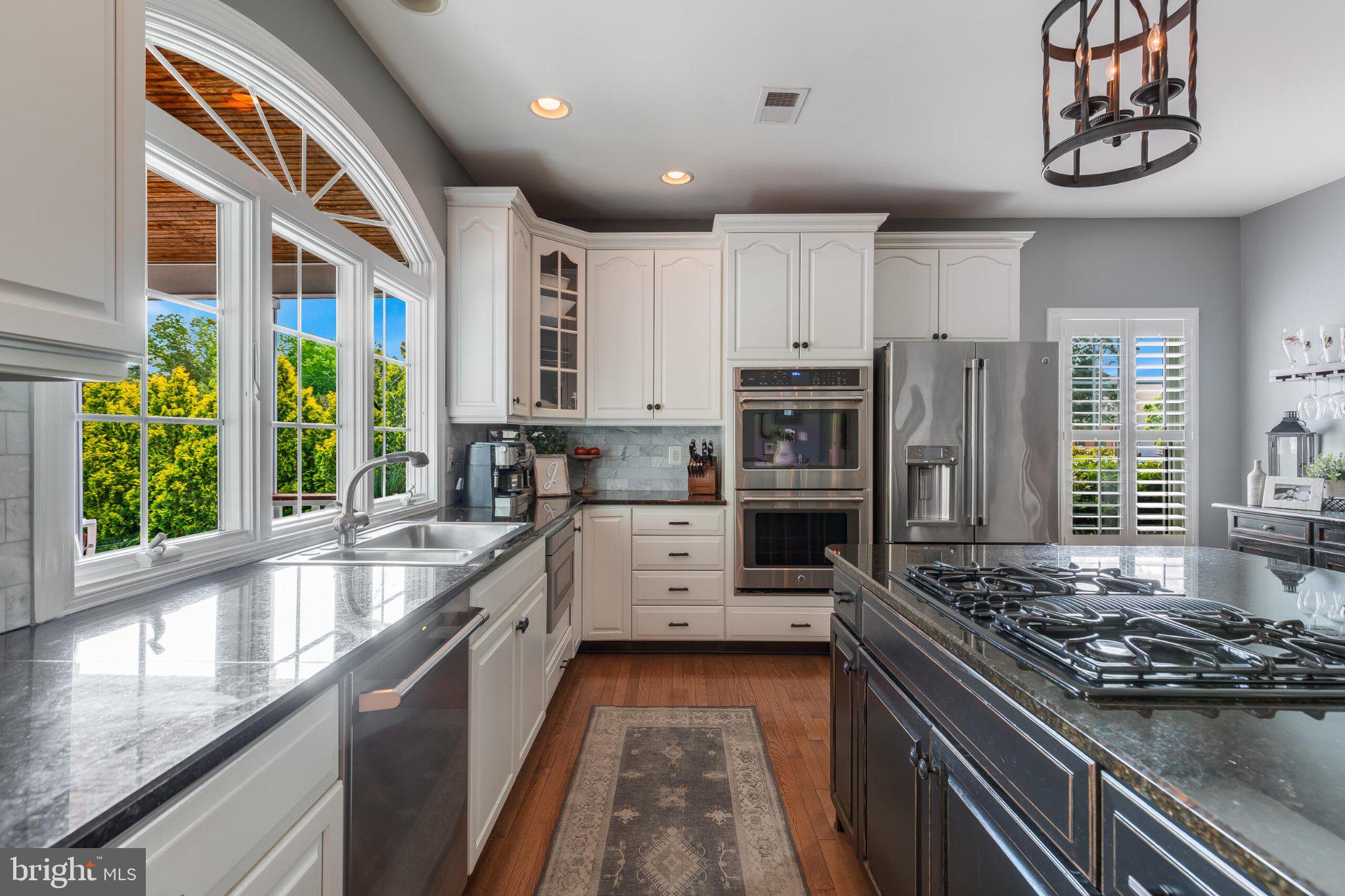 25554 Mimosa Tree Court Chantilly, VA 20152 - Photo 32 of 85 a kitchen with stainless steel appliances granite countertop a stove a sink and a microwave