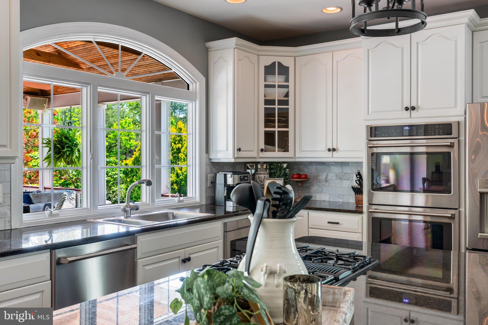 25554 Mimosa Tree Court Chantilly, VA 20152 - Photo 33 of 85 a kitchen with stainless steel appliances a stove a sink and a window