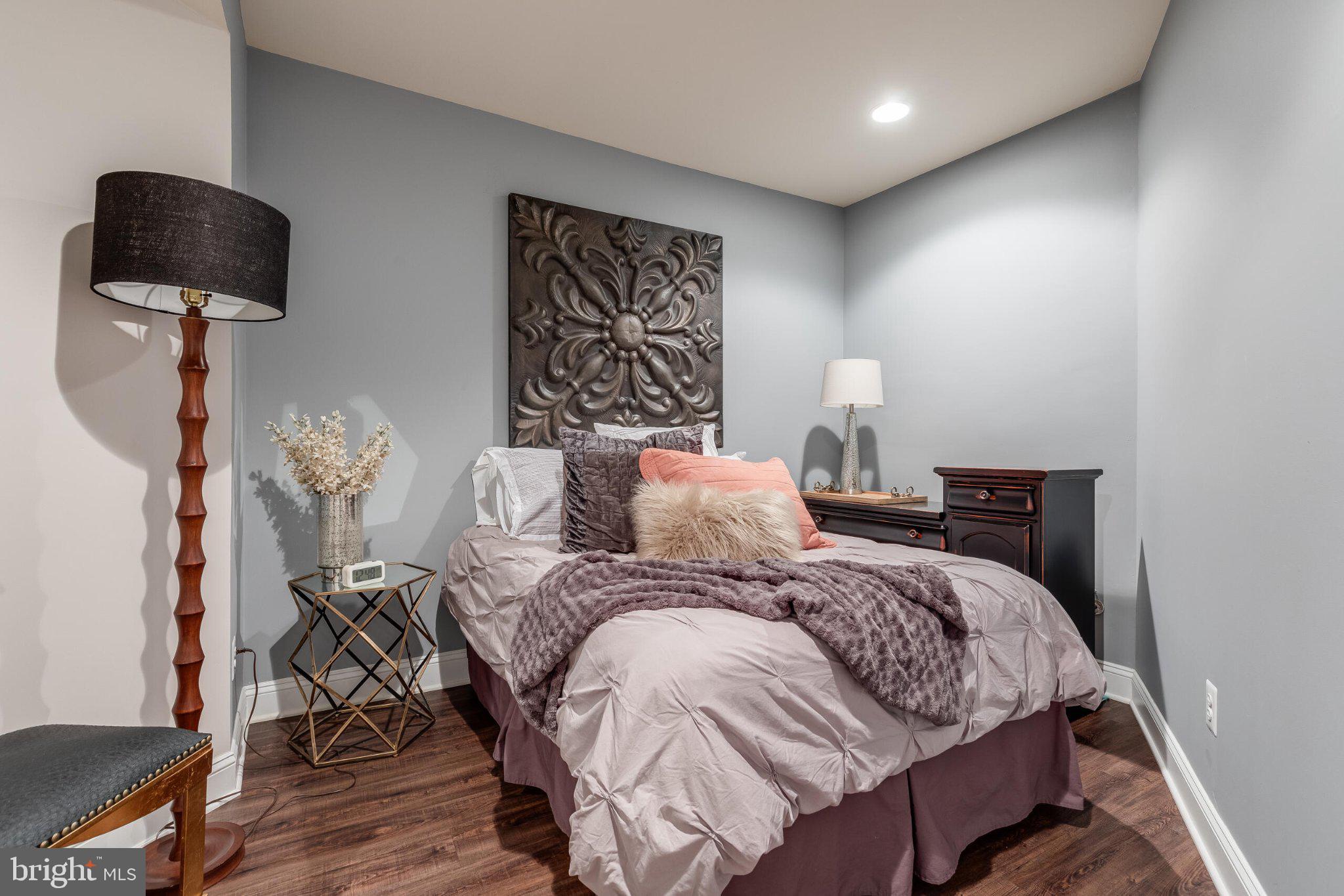 25554 Mimosa Tree Court Chantilly, VA 20152 - Photo 68 of 85 a bedroom with a bed a lamp and a potted plant