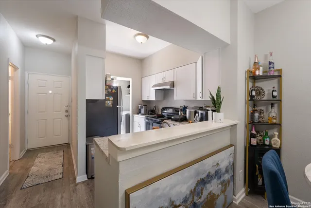 a kitchen with stainless steel appliances kitchen island granite countertop a refrigerator and a sink