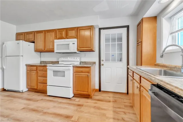 a kitchen with white cabinets and white appliances