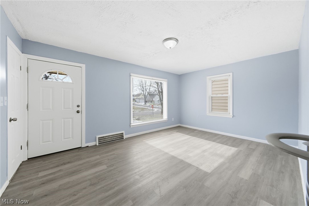 20705 Hansen Road Maple Heights, OH 44137 - Photo 2 of 24 Entryway featuring light wood-style floors and a textured ceiling