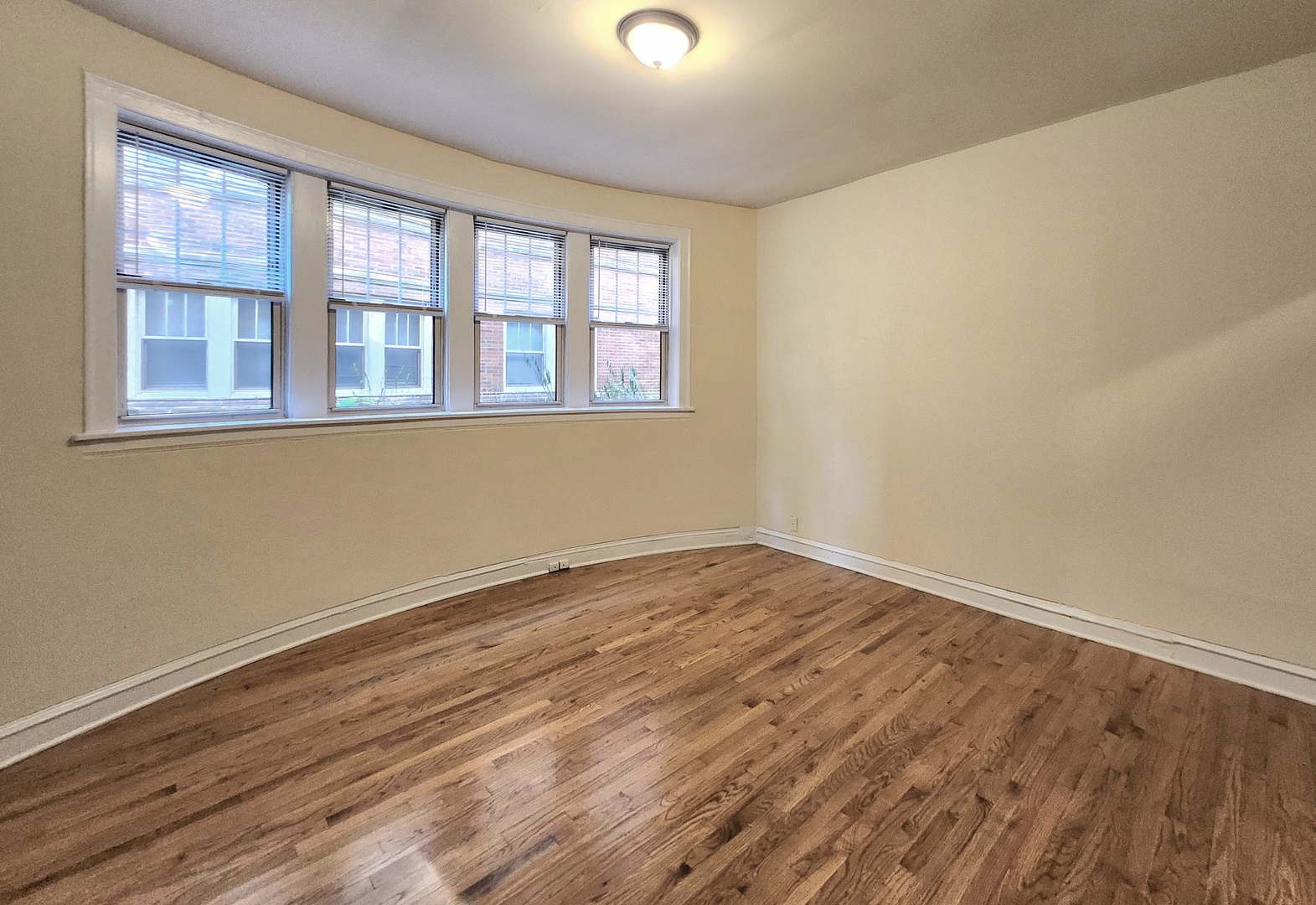 3746 West Irving Park Road, Unit GDN Chicago, IL 60618 - Photo 2 of 11 a view of an empty room with wooden floor and a window