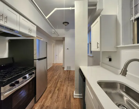 a kitchen filled with stainless steel appliances a stove a sink and a refrigerator