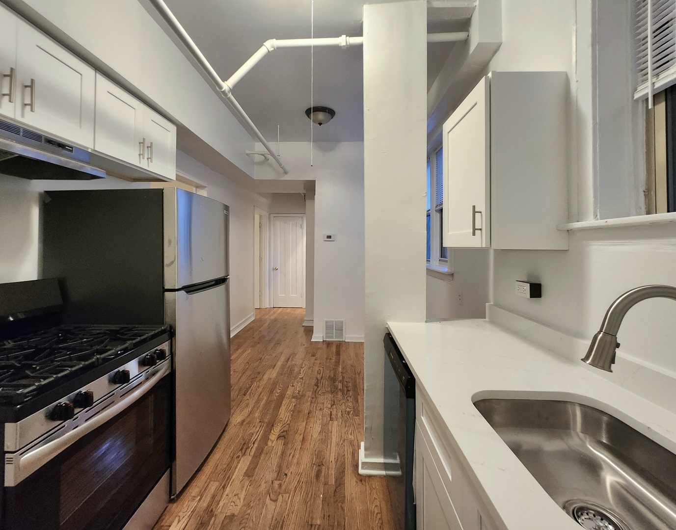 3746 West Irving Park Road, Unit GDN Chicago, IL 60618 - Photo 6 of 11 a kitchen filled with stainless steel appliances a stove a sink and a refrigerator