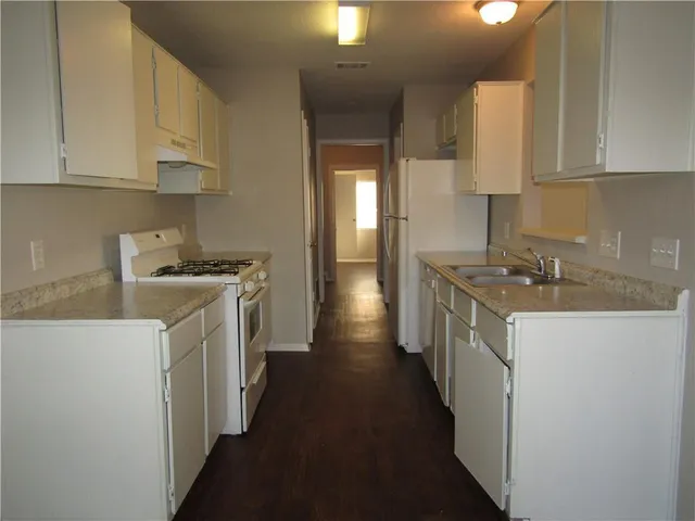 a kitchen with stainless steel appliances a sink stove and cabinets