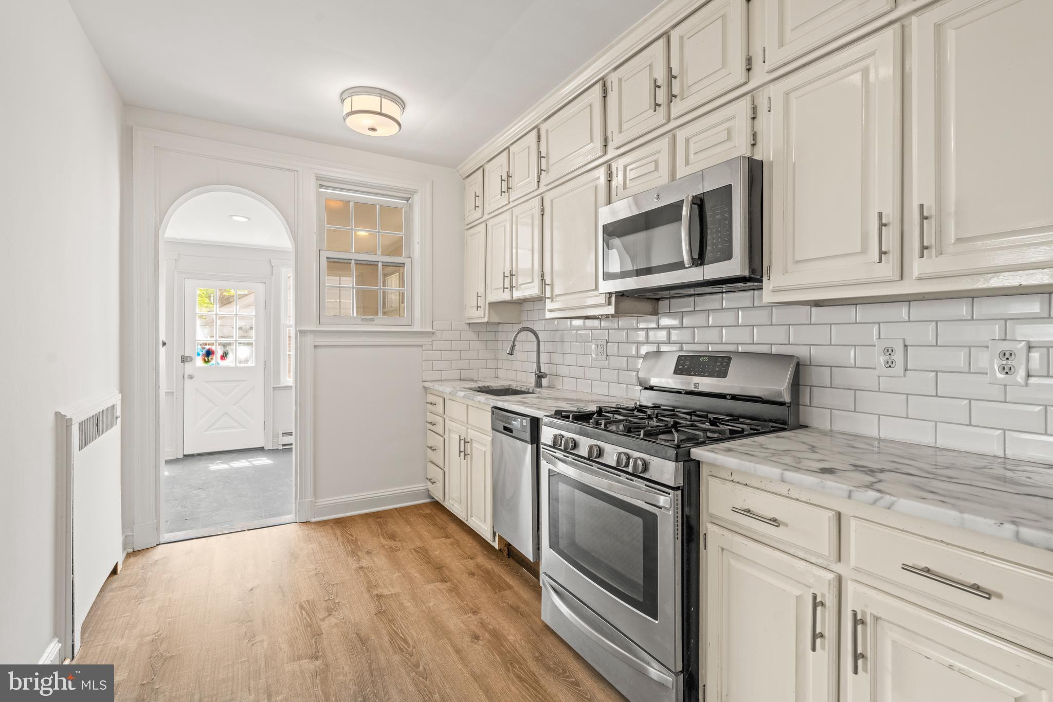 309 Hopkins Road Baltimore, MD 21212 - Photo 12 of 36 a kitchen with stainless steel appliances granite countertop a stove and a microwave