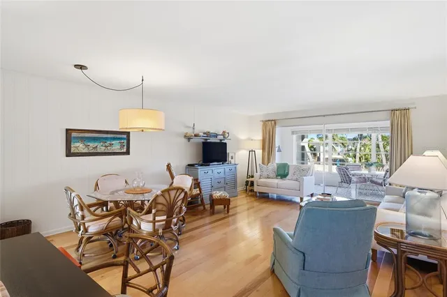 a living room with furniture kitchen view and a large window