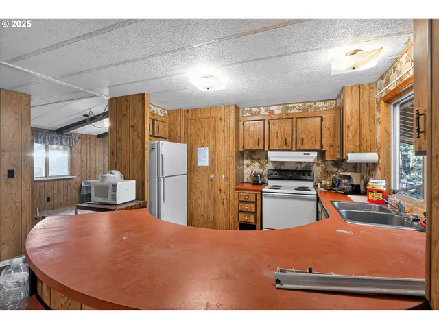 a kitchen with stainless steel appliances granite countertop a sink a stove and refrigerator