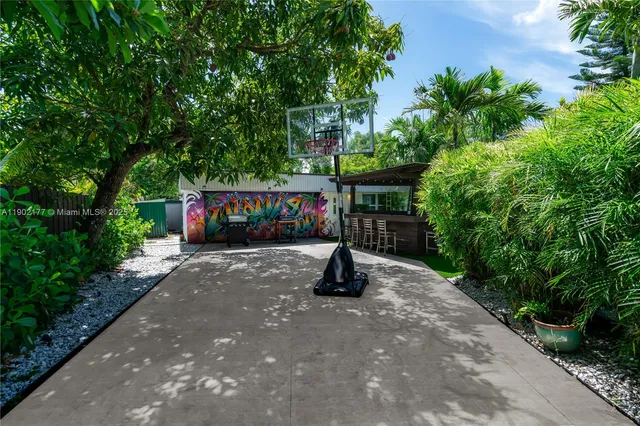 a view of a street with potted plants and large trees