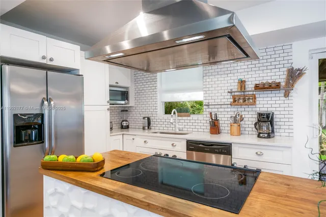 a kitchen with stainless steel appliances granite countertop a sink and a refrigerator