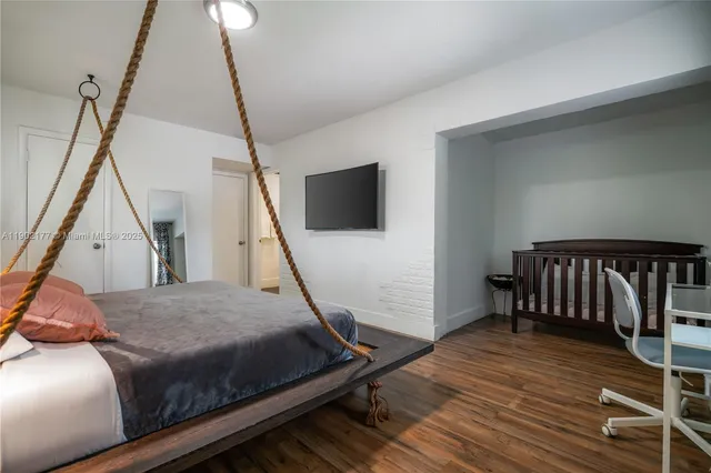 a bedroom with a bed window and a flat screen tv