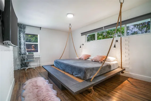 a bed room with a bed window and potted plants