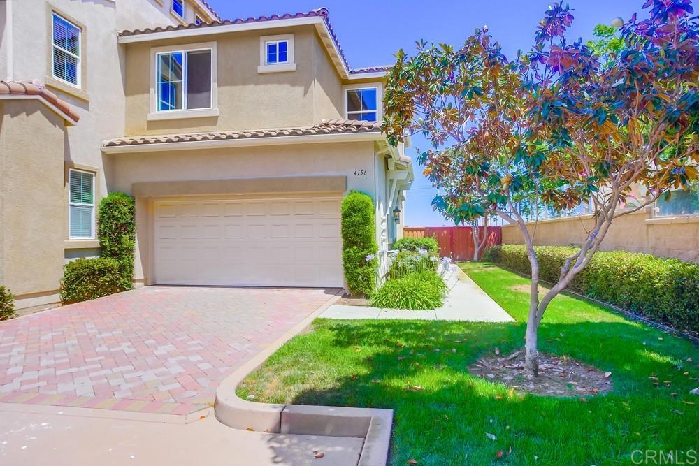 a front view of a house with a yard and fountain