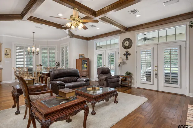 a living room with furniture a large window and wooden floor