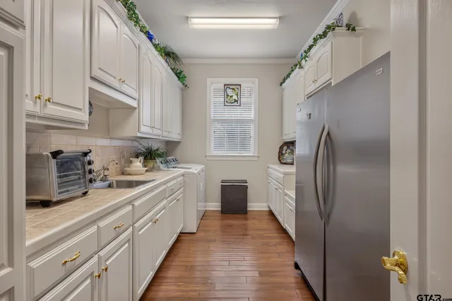 a kitchen with stainless steel appliances a refrigerator sink and white cabinets