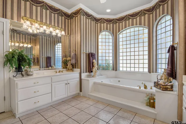 a spacious bathroom with a double vanity sink mirror and a bathtub