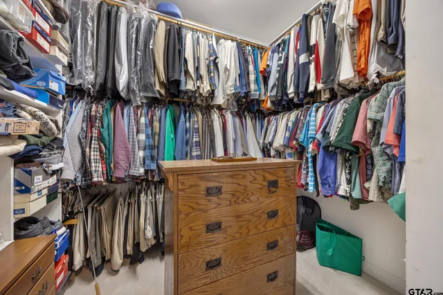 a view of walk in closet with clothes and shoes