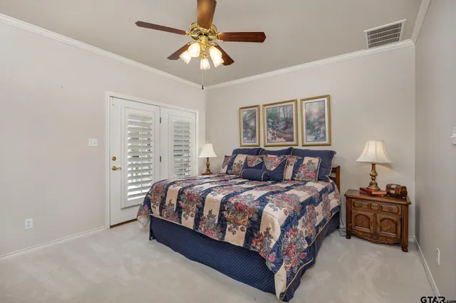 a bedroom with a bed a chandelier and a couch