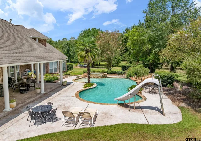 a swimming pool with outdoor seating and yard