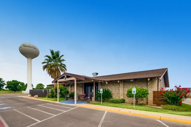 a view of a house with a yard and potted plants