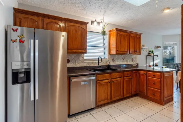 a kitchen with stainless steel appliances granite countertop a refrigerator and a sink