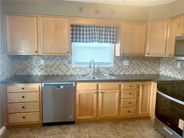 an empty room with wooden floor fireplace and windows