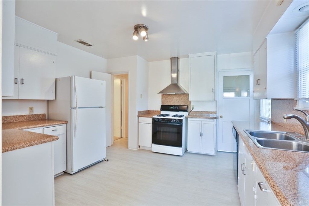2235 Garfias Drive Pasadena, CA 91104 - Photo 9 of 40 a kitchen with stainless steel appliances granite countertop a refrigerator sink stove and white cabinets