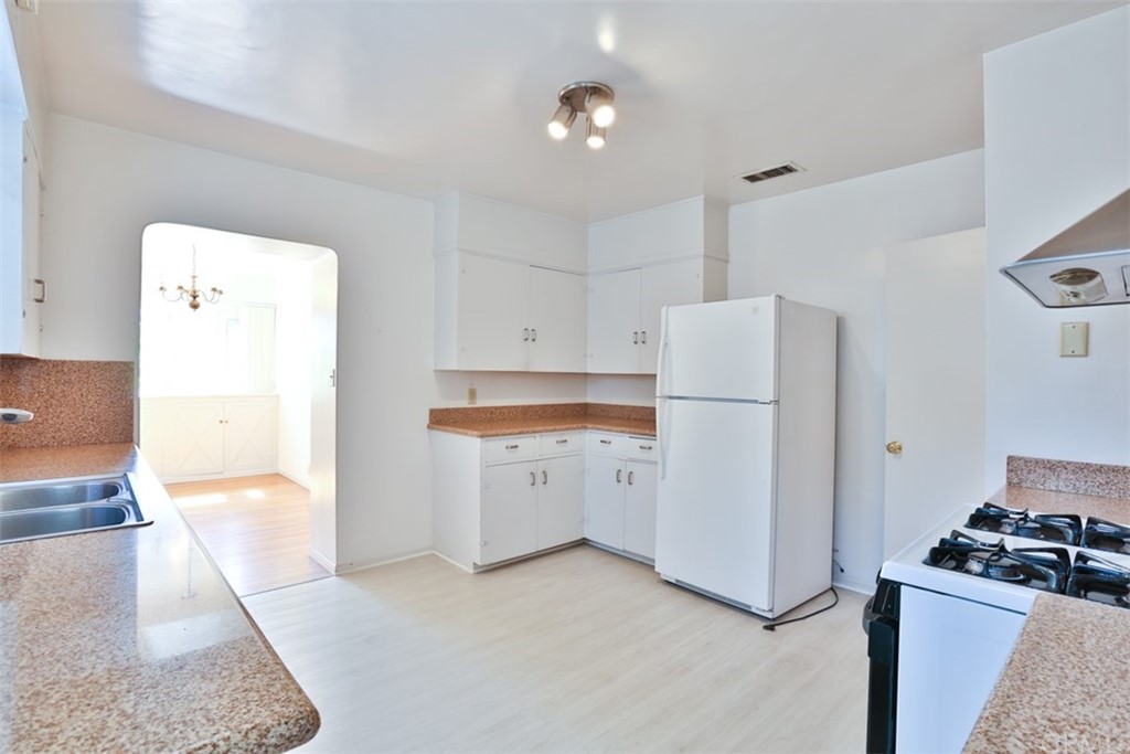 2235 Garfias Drive Pasadena, CA 91104 - Photo 10 of 40 a kitchen with a refrigerator a stove top oven and cabinets