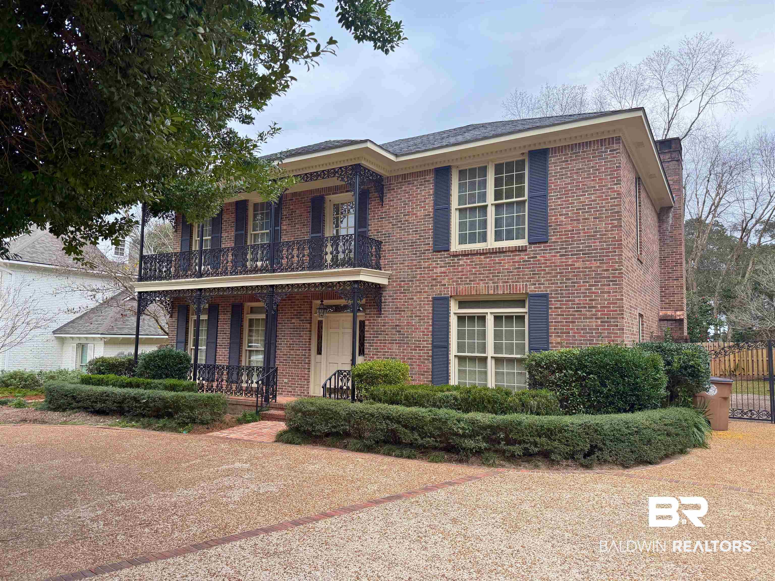 53 Warwick Road Mobile, AL 36608 - Photo 3 of 45 View of front facade featuring a balcony, covered porch, brick siding, and a chimney
