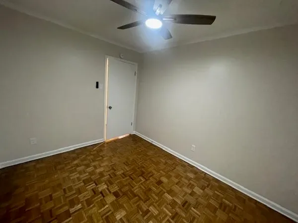 an empty room with a fan & a window