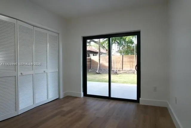 an empty room with wooden floor and doors