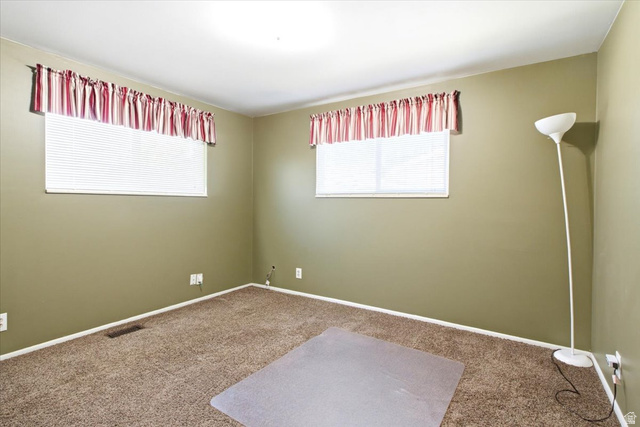 7050 South 260 East Midvale, UT 84047 - Photo 15 of 28 Carpeted room featuring two windows with horizontal blinds and valances, light olive-toned walls, and white baseboards