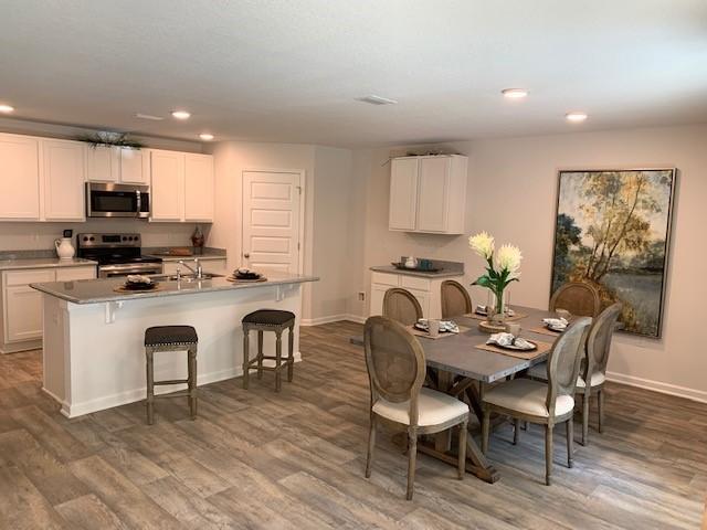 2826 Patriots Rdg Drive Crestview, FL 32539 - Photo 5 of 25 a kitchen with kitchen island granite countertop a dining table chairs a sink and cabinets