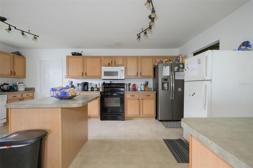 11 Riddle Drive Palm Coast, FL 32164 - Photo 8 of 33 a kitchen with a refrigerator a stove top oven a sink and cabinets
