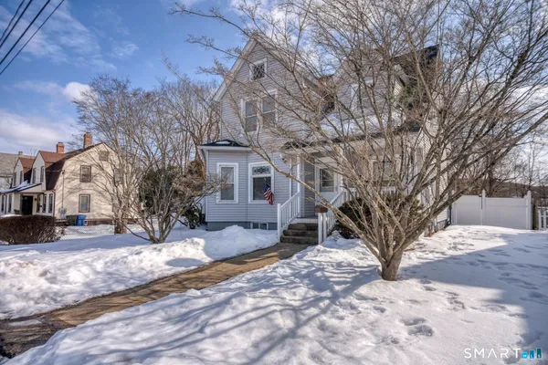 a view of a house with a yard covered in snow